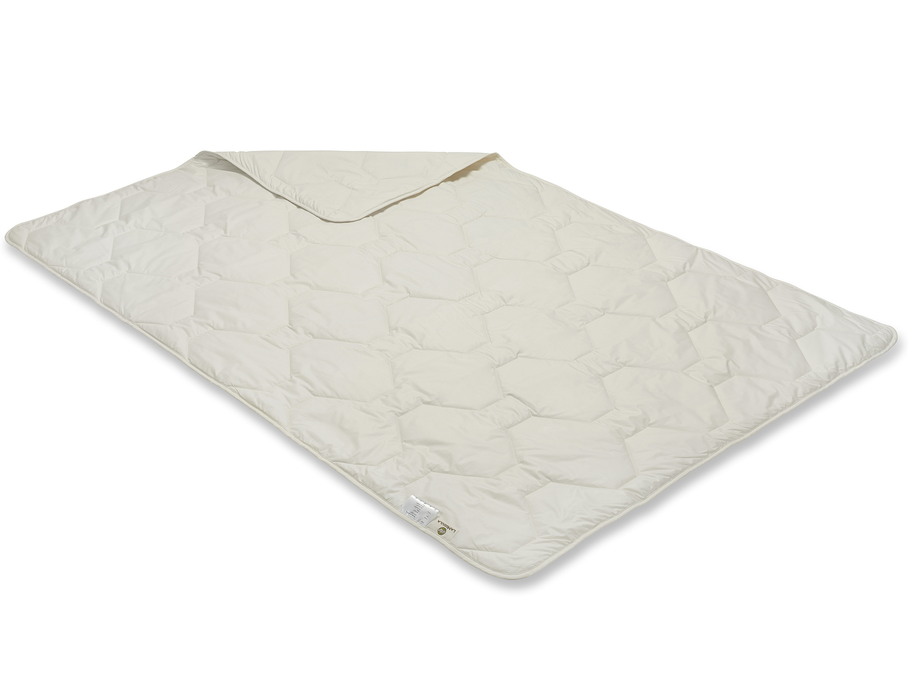 Durch die Herstellung mit der Vielnadeltechnik entsteht ein gleichmäßiges Muster. Die Decke schimmert cremig.